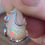 Thumbnail: Welo opal pendant resting on a smooth stone surface. Its translucent body and fiery play-of-color catch the light beautifully