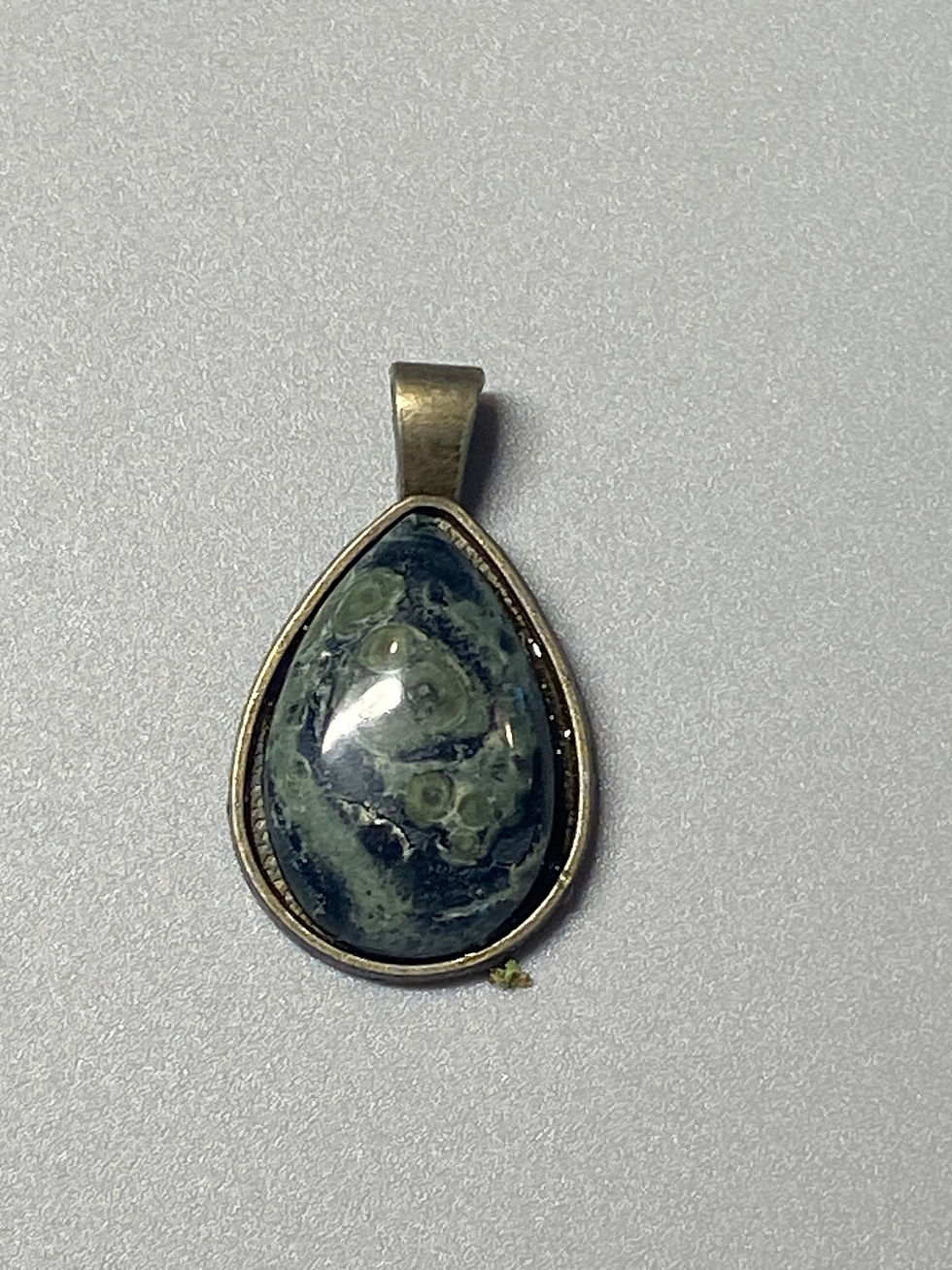 Teardrop Kambaba Jasper pendant with a smooth finish and copper-tone  backing.