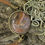 Thumbnail: Close-up of Butte Creek Agate stone on a leather bracelet, displayed against a tree bark background.