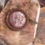 Thumbnail: Close-up of a leopard skin jasper pendant with intricate wooden detailing.