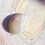 Thumbnail: A polished Butte Creek Agate stone with natural beige and cream banding placed on a geode background.
