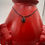 Thumbnail: Full view of the Tiger Eye pendant on a leather cord draped over a red ceramic vase.