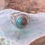 Thumbnail: A sterling silver ring featuring a domed Royston turquoise cabochon, displaying earthy green and blue tones with golden matri