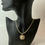 Thumbnail: Angled view of Tiger Eye pendant showcasing its golden-brown hues, placed on a textured crystal surface.