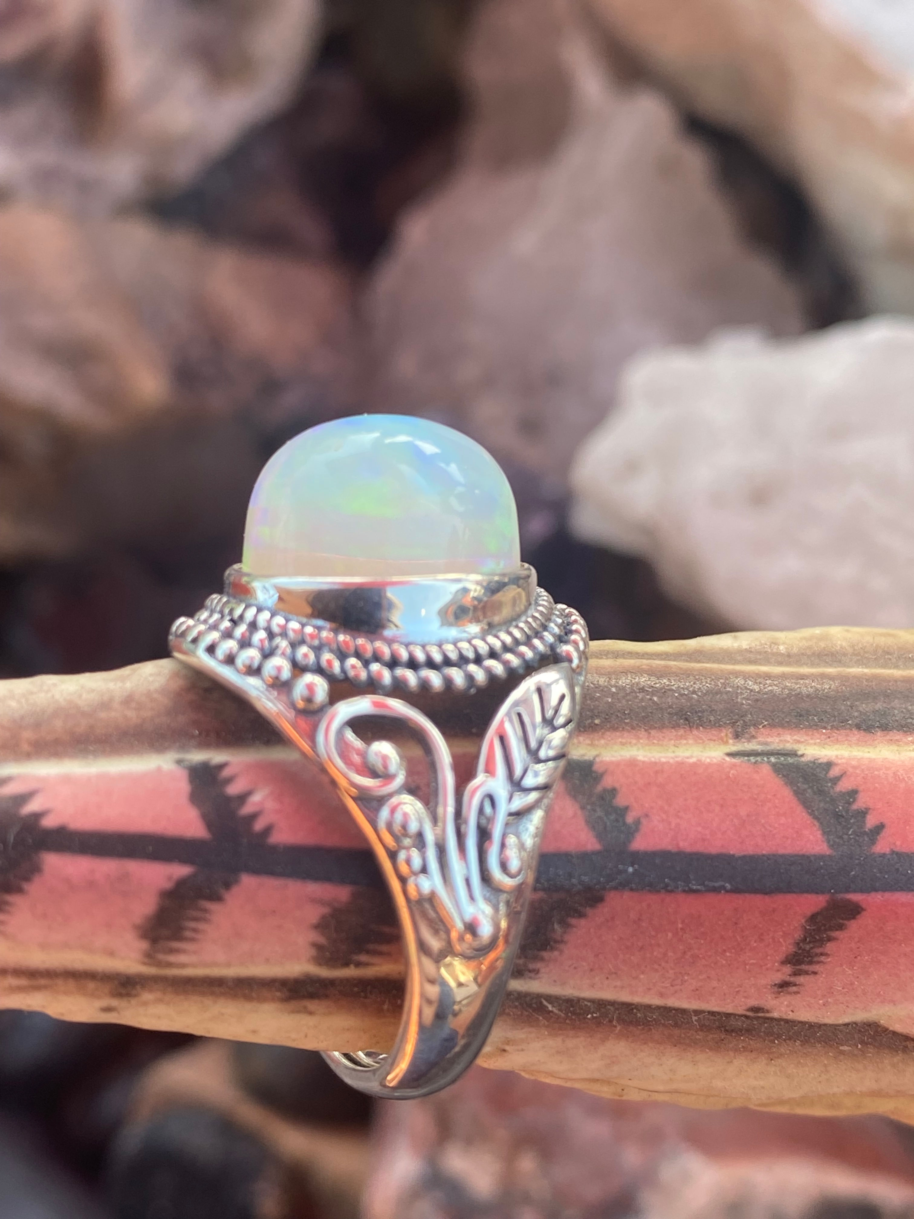 Side view of a Welo opal ring showcasing the gemstone’s colorful play-of-light and ornate silverwork