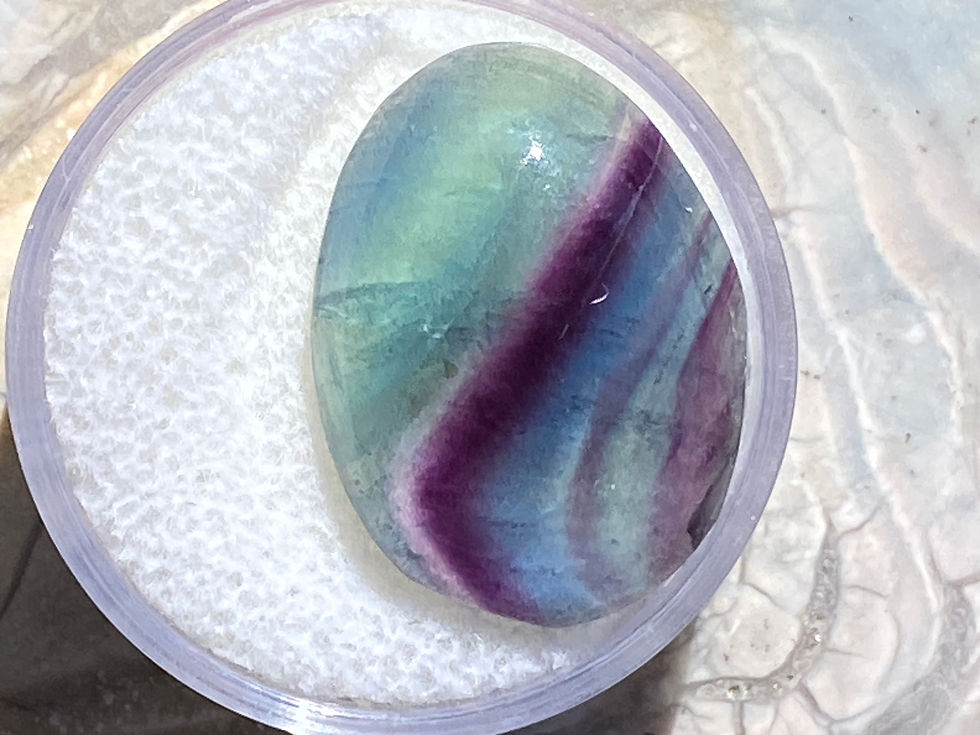 Thumbnail: Image of a polished Fluorite gemstone with vibrant green, blue, and purple bands.