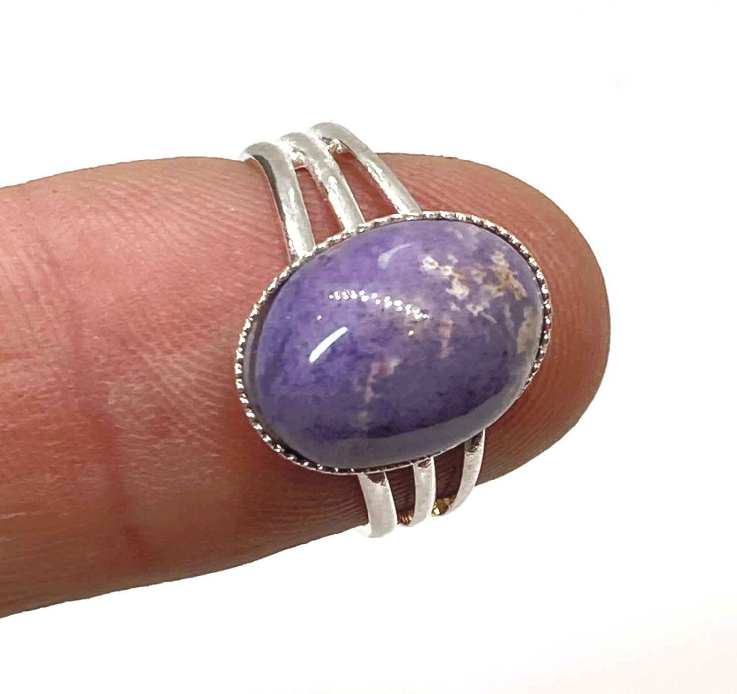 Close-up of Purple Agate ring with a silver band, held between fingers, highlighting the gemstone’s smooth surface and vibran