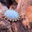 Thumbnail: Elegant Larimar pendant with intricate silver-plated setting, displayed on natural wooden backdrop.