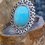 Thumbnail: Side view of Oval-shaped Arizona turquoise ring set in an ornate silver-plated band with intricate scrollwork.