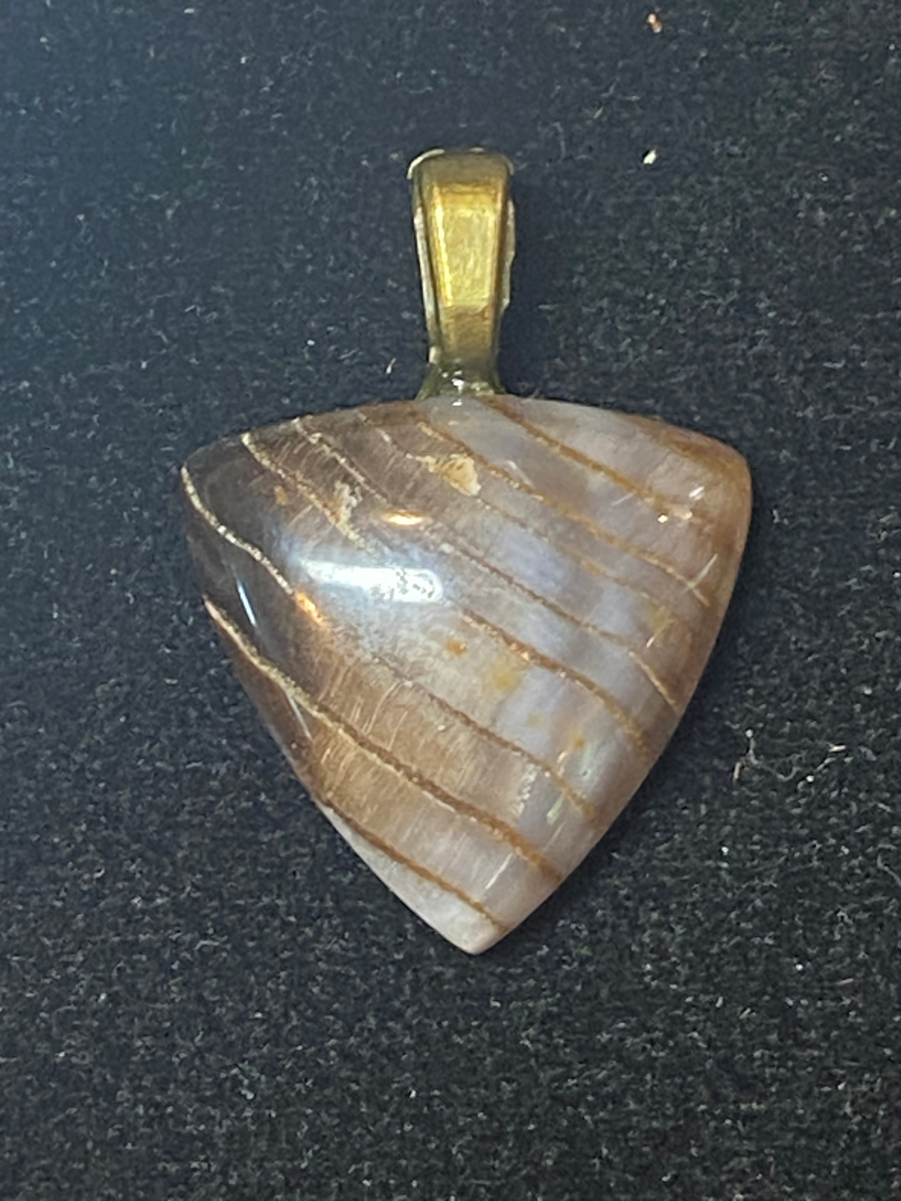 Triangular Banded Agate pendant with a polished finish set in a gold-tone bail.