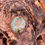 Thumbnail: Close-up of Prehnite Bronze Pendant showcasing its faceted round gemstone in a bronze setting.