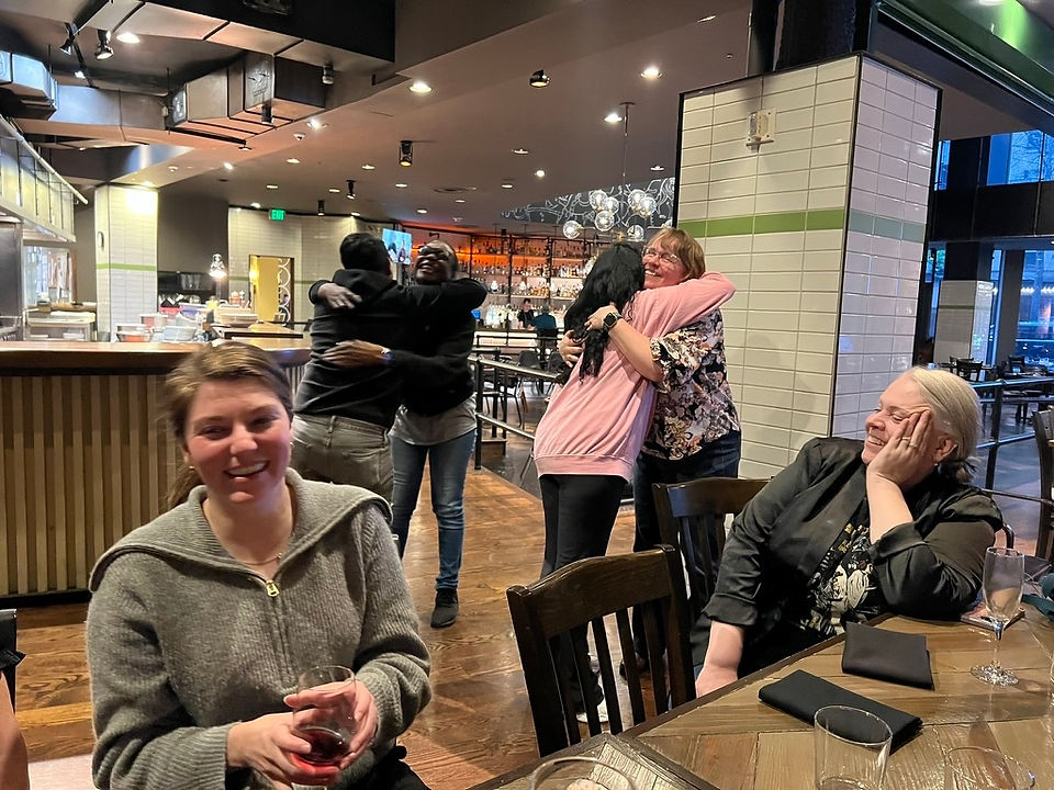 ScribeConcepts team members meet each other for the first time, giving hugs.