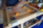 using corner clamps to fix a wooden frame in place for gluing