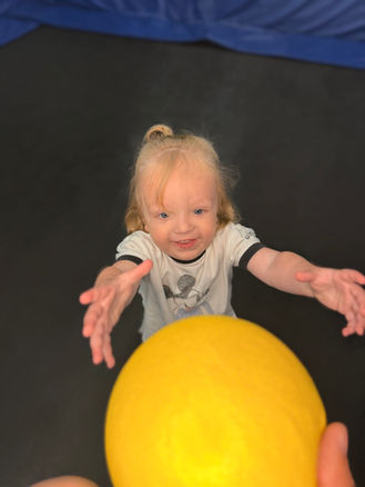 Toddler playing with a yellow ball at Jump Air Zone