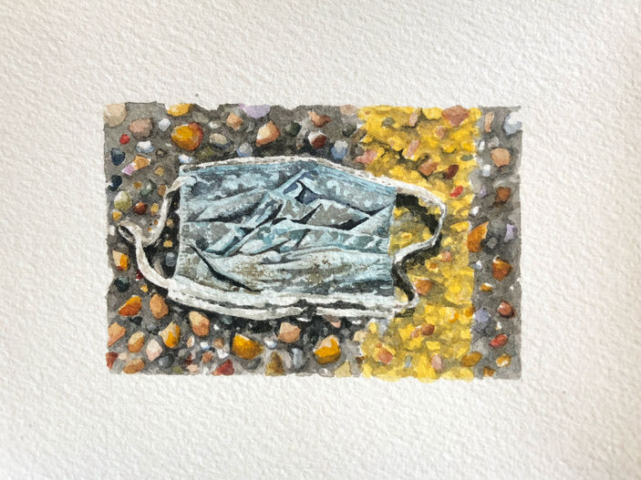 closeup painting of a mask on asphalt with a yellow line