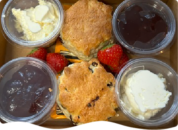 Scones with clotted cream, jam, strawberries and tea make up this cream tea classic