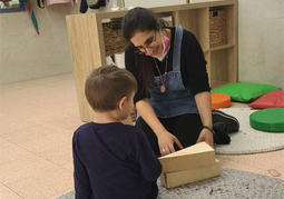 עובדת בגן משחקת עם ילד