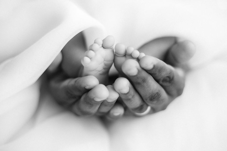 newborn feet in dad's hands
