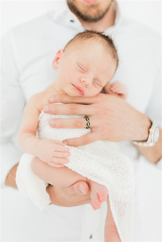 Baby sleeping in dad's hand