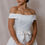 Thumbnail: Dark haired model wearing 1994 Vera Wang wedding dress with overskirt against beige backdrop