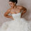 Thumbnail: Dark haired model wearing vintage Vera Wang wedding dress and sitting on a beige backdrop