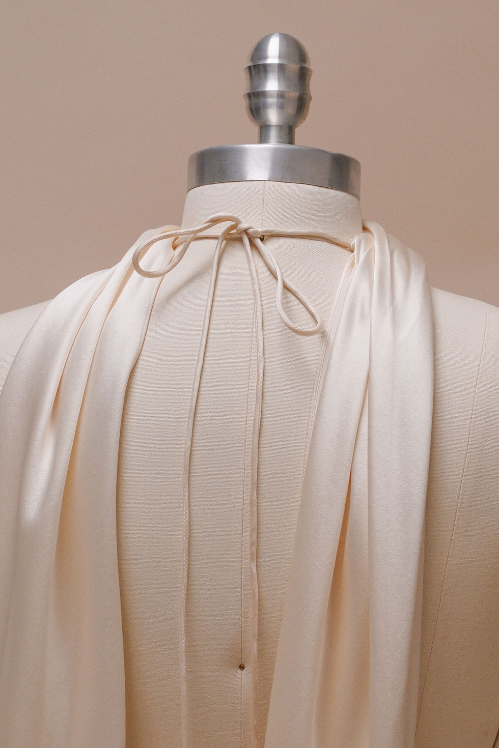 Thumbnail: Vintage 2003 Ralph Lauren wedding dress with halter neck on a dress form against an ivory backdrop