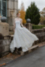 Red haired model wearing tiered tulle vintage wedding dress while standing on stone staircase