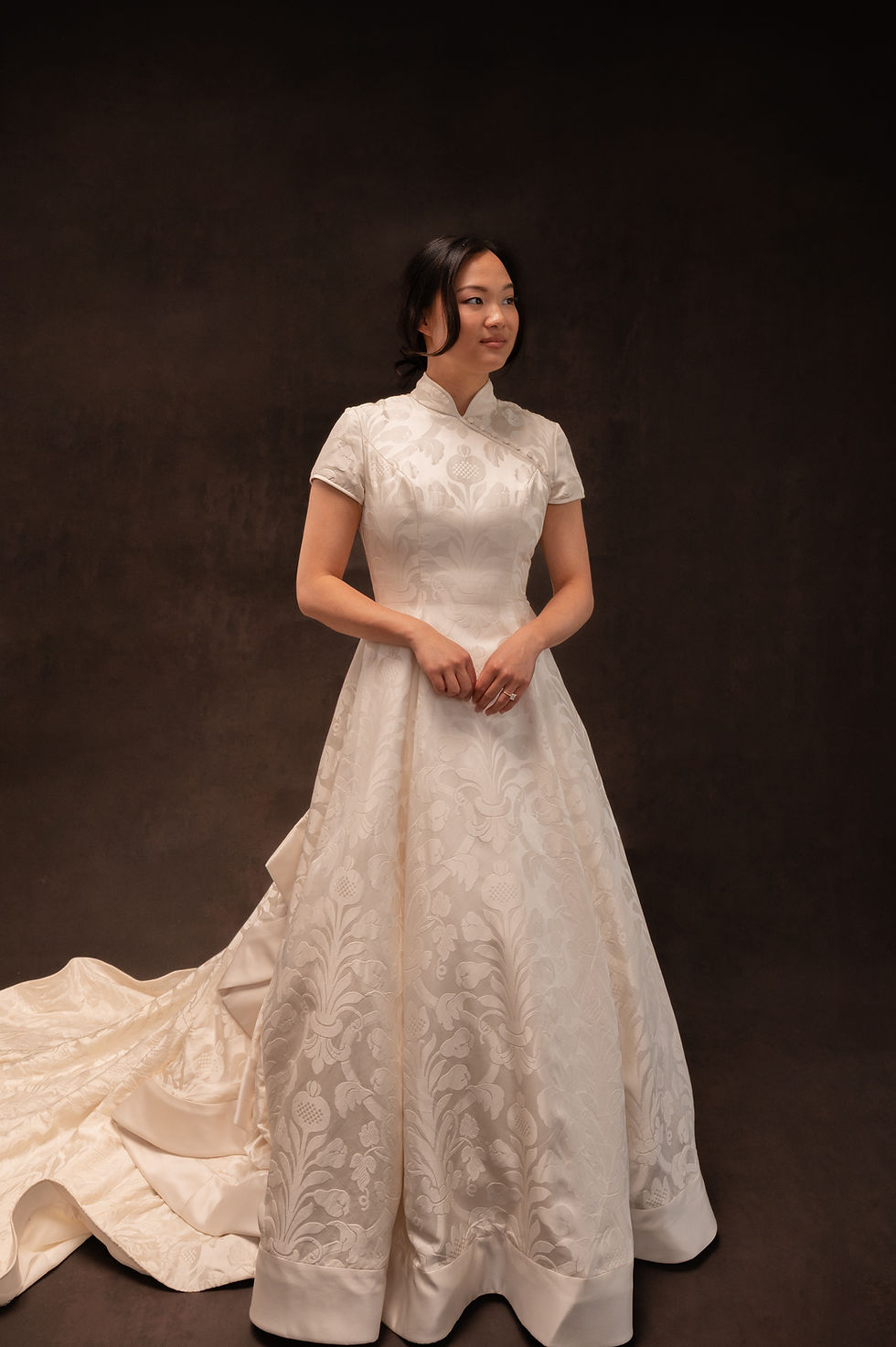 Model wearing high neck vintage wedding dress against brown backdrop at Atlanta bridal shop