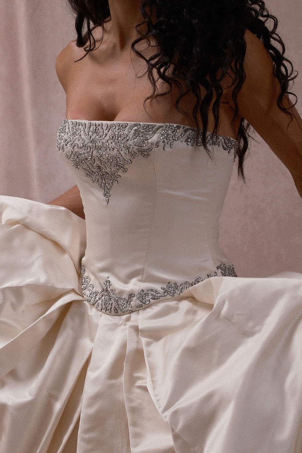 Thumbnail: Curly haired model showing off bodice detail of 1999 Vera Wang ball gown