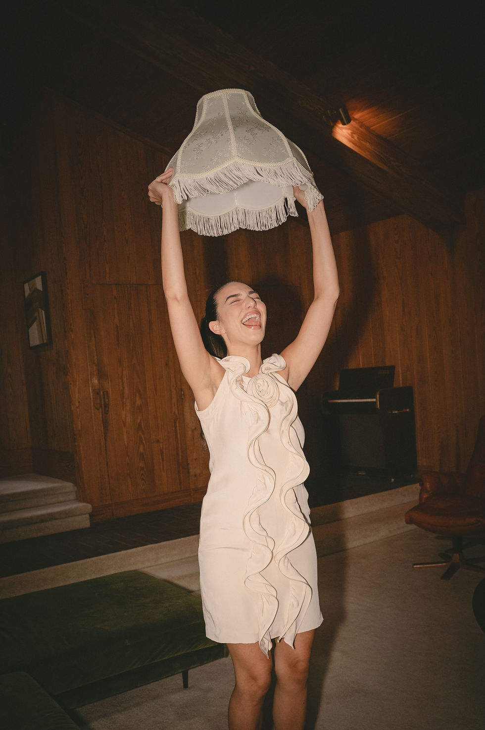 Bride wearing vintage Oscar de la Renta mini dress while laughing and holding a lampshade