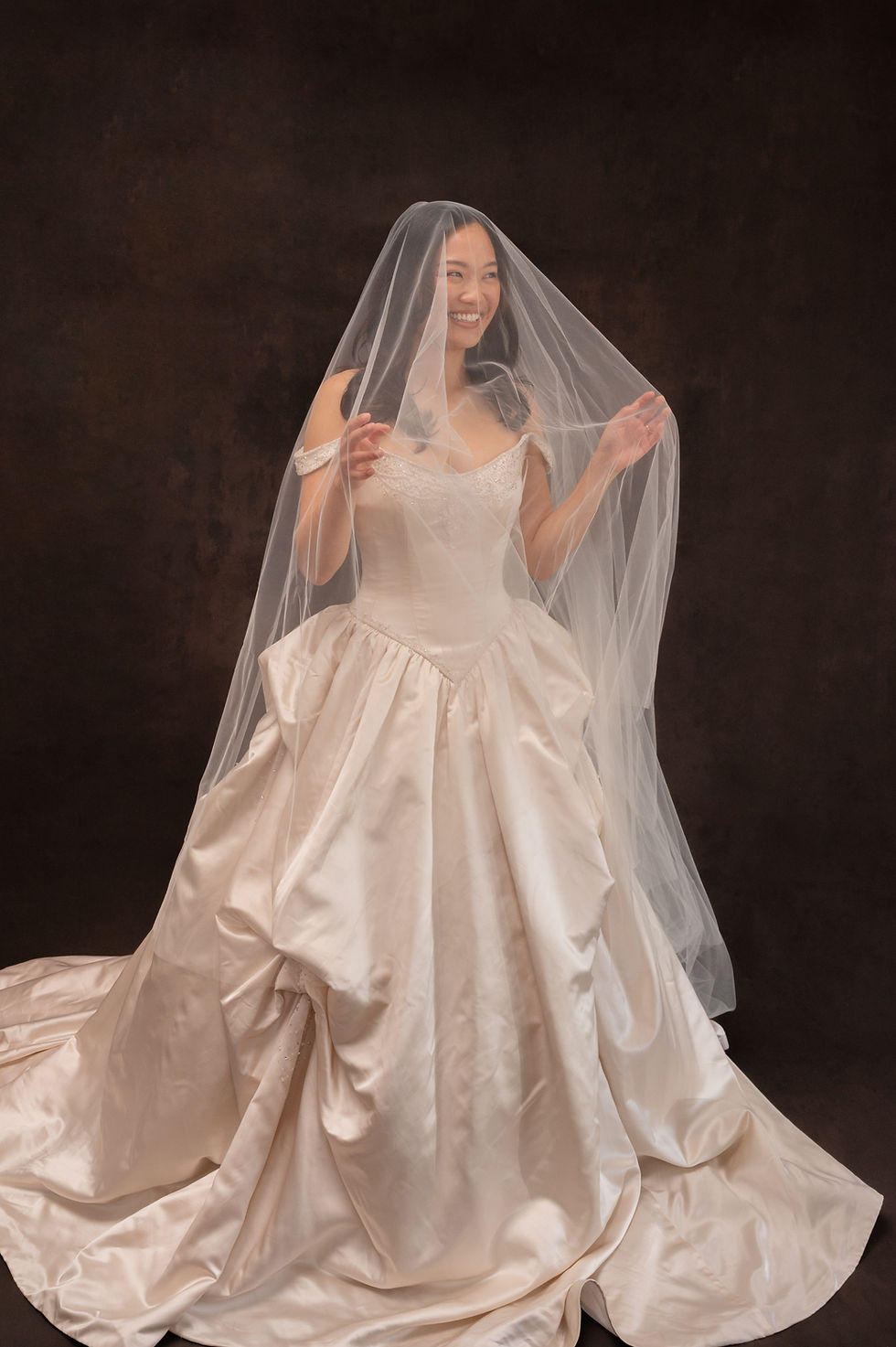 Thumbnail: Model wearing dramatic pink silk vintage wedding dress against brown backdrop