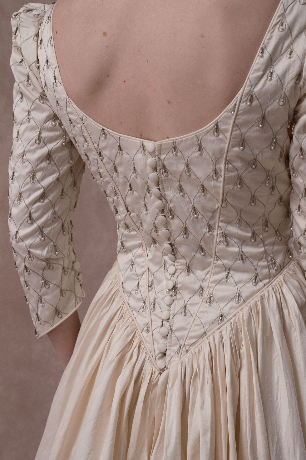 Thumbnail: Red haired model wearing vintage French silk wedding dress against beige backdrop