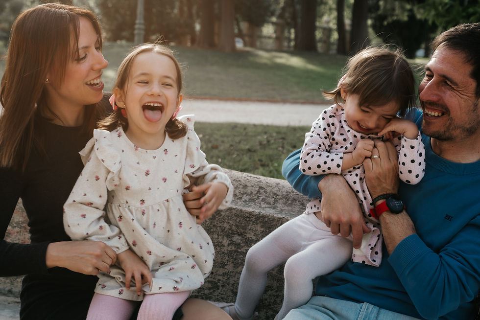 Padres e hijas en un momento de diversión y sonrisas en un parque de Valencia.