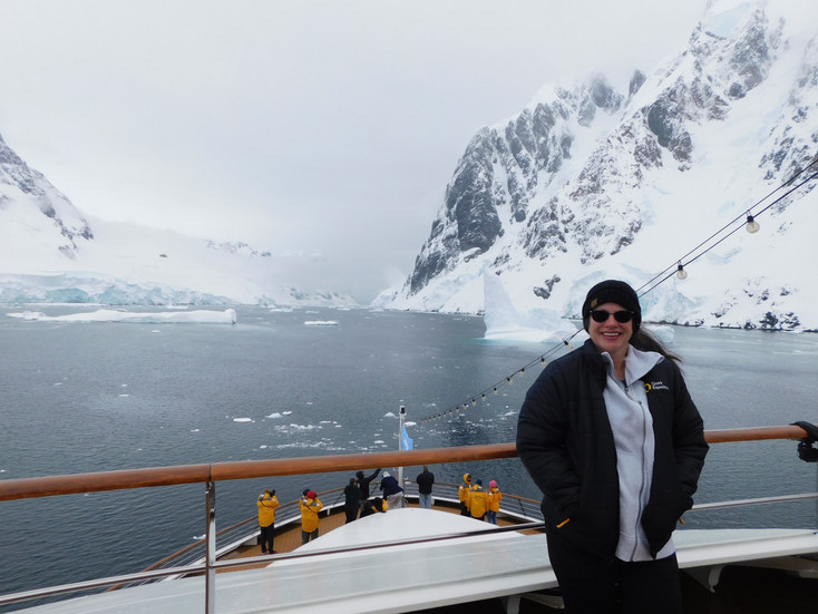 The author on deck in Antarctica with observation deck and icebergs in the background