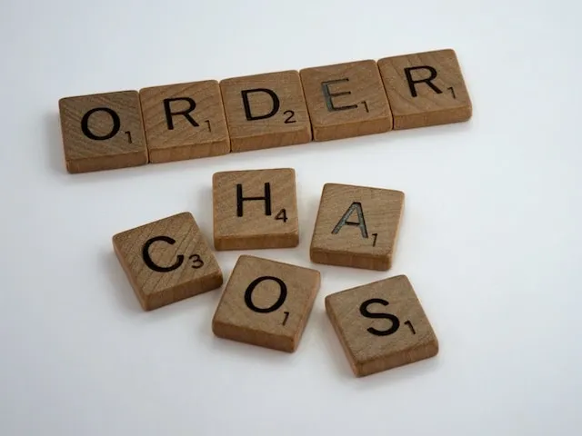 Wooden scrabble letter showing the order in a line, and the word chaos chaotically not in order