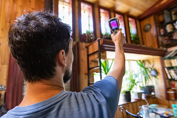 A closeup and rear view of male building inspector carrying out an indoor environmental qu