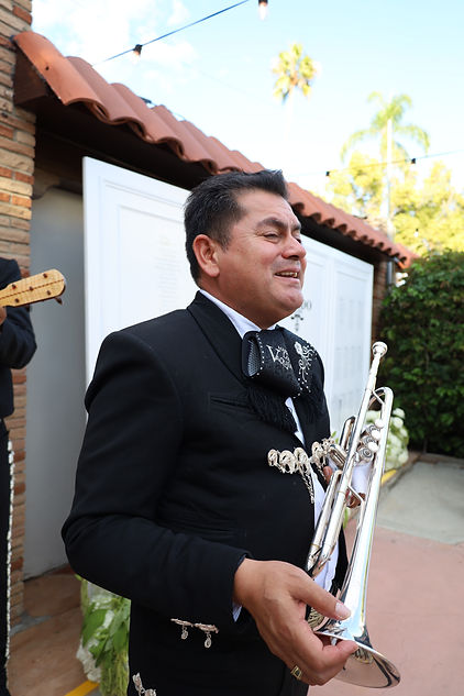 Mariachi Vaqueros trumpet musician smiling after a live performance in Los Angeles, showcasing traditional mariachi style and elegance.