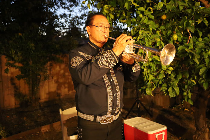 Mariachi trumpeter performing at a nighttime backyard celebration in the Bay Area