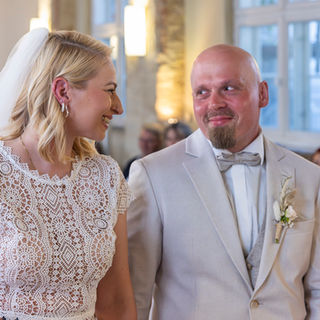 Hochzeitspaar steht im Trauzimmer des Heinrich-Heine- Haus in Lüneburg und lächelt sich an