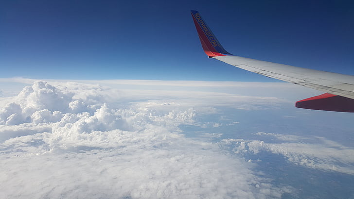 Wing of plane over clouds.