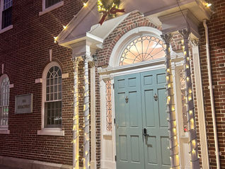 Parents’ Foundation building decorated with Christmas lights and a festive wreath, glowing warmly in the evening.