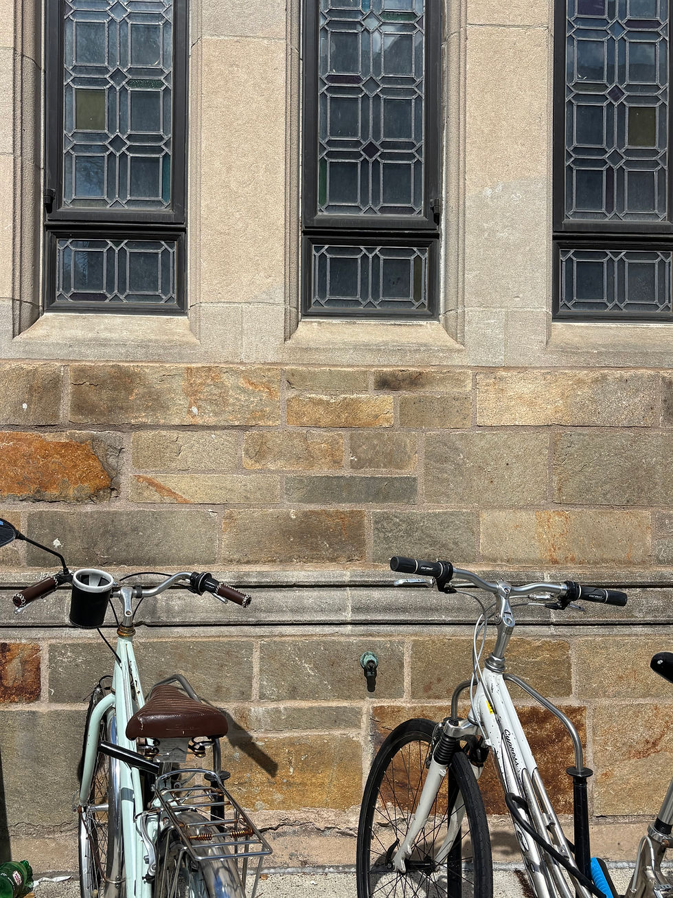 A row of bicycles parked against a brick building, suggesting everyday neighborhood life and outdoor activity.