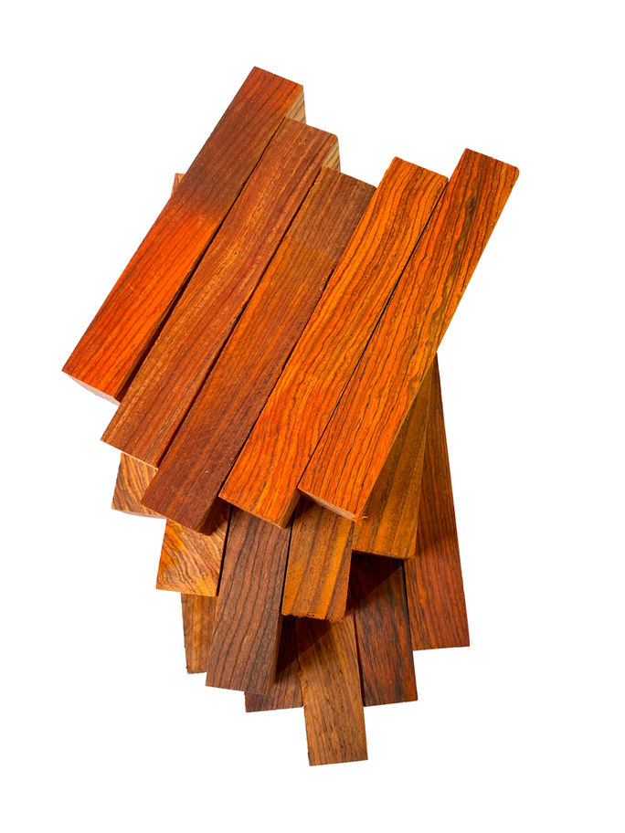 Several pieces of lumber stacked, showcasing color and grain. Highly Figured Mahogany Lumber, Diamond Tropical Hardwoods