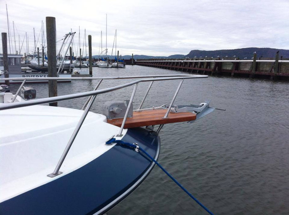 Boat's bow with the water and bridge in the background on a cloudy day.