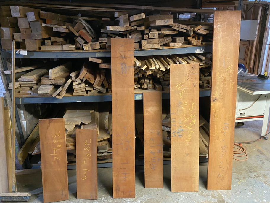 Several Premium Figured Mahogany Boards displayed in a workshop storage room with lumber.