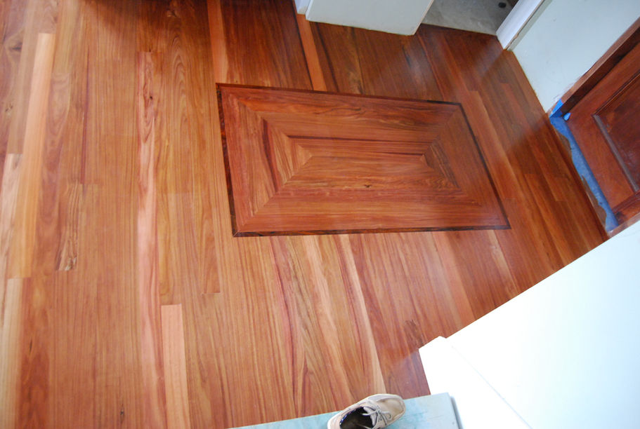 Wooden floor with a decorative rectangle and a white shoe displayed