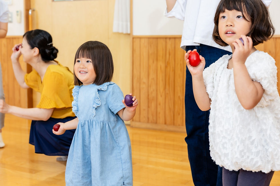 楽しそうにマラカスをふる女の子 リトミックレッスン