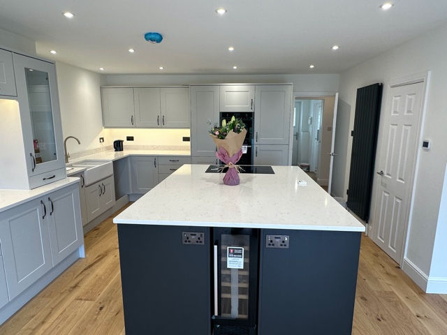 Kitchen island with integrated wine cooler and pendant lighting