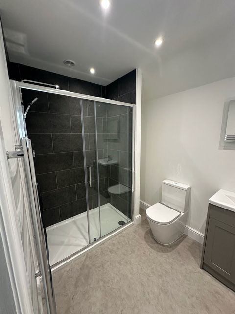 Refurbished shower room with glass enclosure and modern tiling