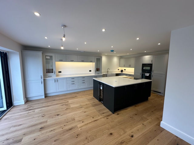 Renovated kitchen with central island and wood flooring
